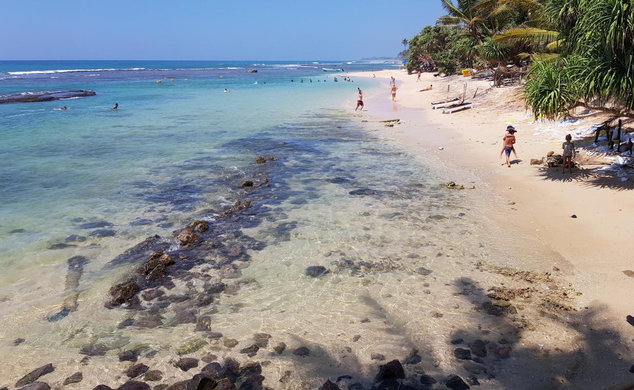 Foto af Madiha Beach med lyst sand & sten overflade