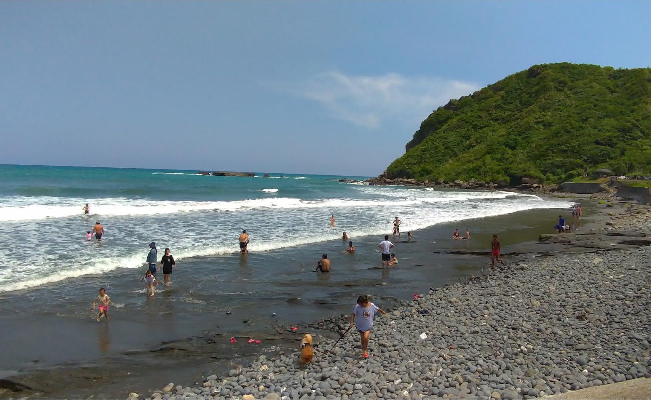 Foto af Jiqi Beach med gråt sand og småsten overflade