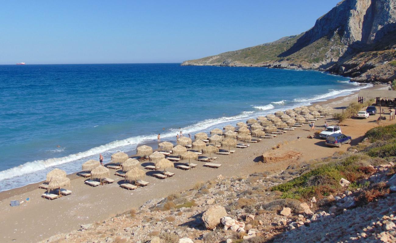 Foto af Kaki Lagkada med sort sand og småsten overflade