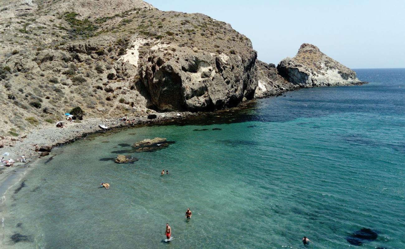 Foto af Cala Higuera med brun sten overflade