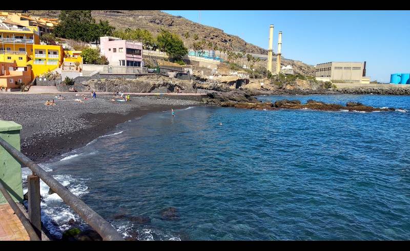 Foto af Playa Las Caletillas med gråt sand og småsten overflade