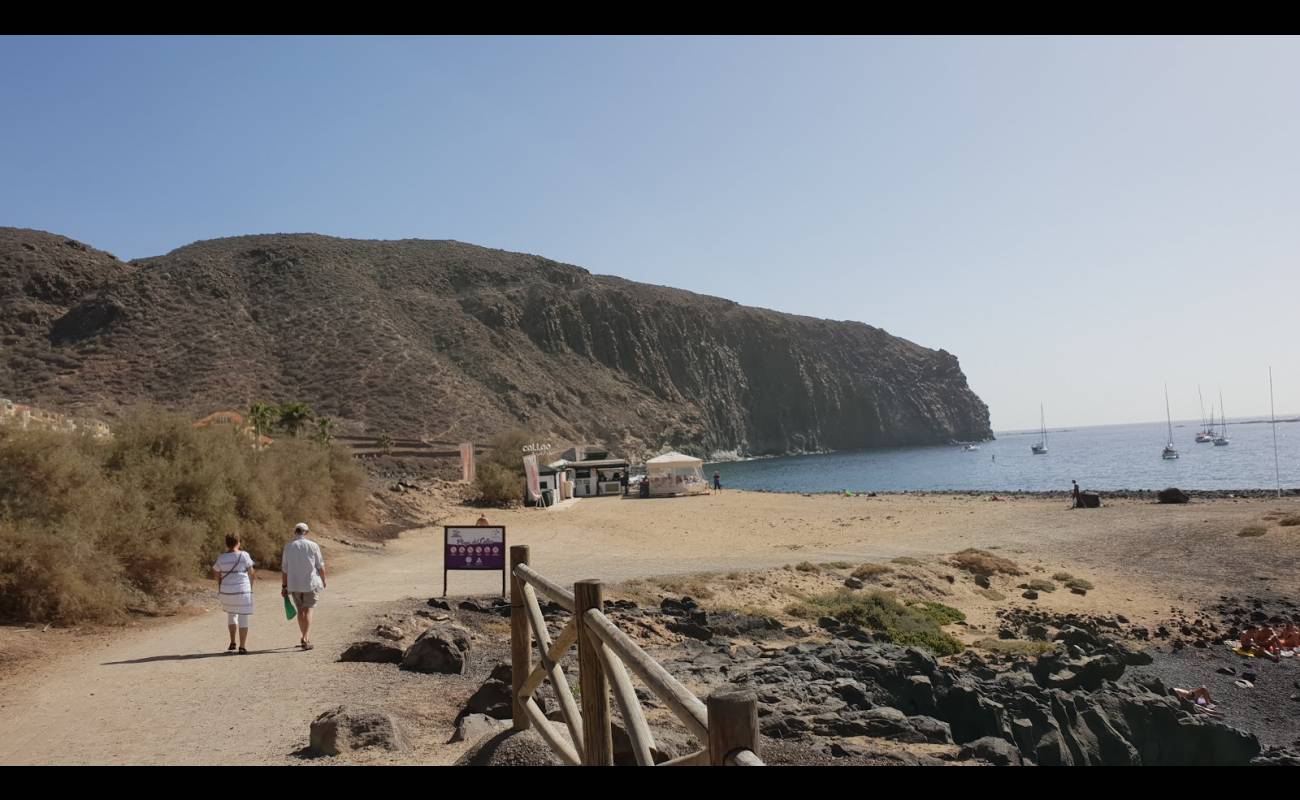 Foto af Playa De Los Hippies med brunt sand og sten overflade