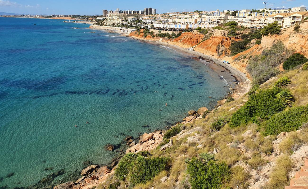 Foto af Cala Aguamarina med grå sand overflade