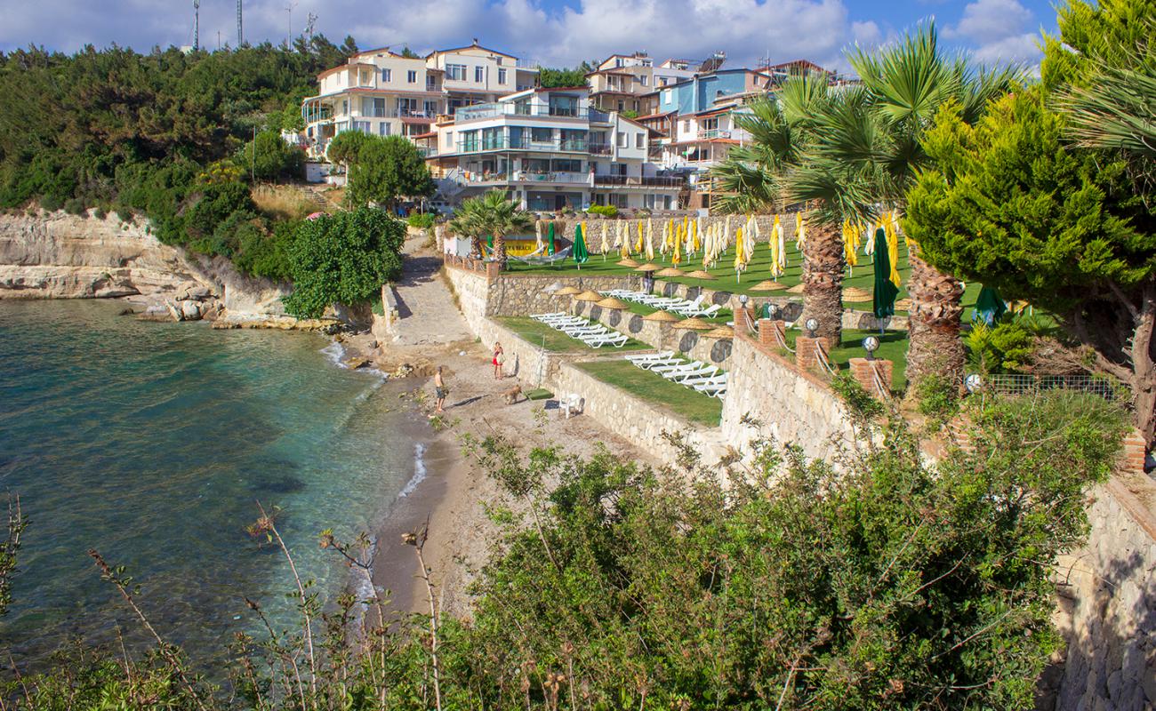 Foto af Aly Beach Club med sort sand og småsten overflade